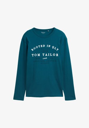 Pamutból készült, hosszú ujjú tótkék póló, kerek nyakkivágással és elöl fehér felirattal: "ROOTED IN QLY, TOM TAILOR, ORIGINAL CUSTOM GOODS."