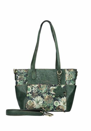Grüne Lederhandtasche mit floralem Muster, zwei Griffen, einem abnehmbaren Riemen und einem blumenförmigen Anhänger, der an einem Griff hängt.