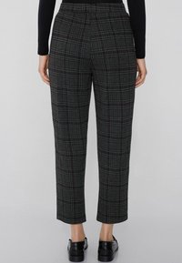 Geruite broek in donkergrijs, met een geplooide ontwerp, op maat gemaakte pasvorm en cropped lengte. Materiaal lijkt textuur te hebben met verticale lijnen.