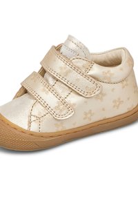 Scarpa in pelle dorata con motivi floreali, presenta due cinturini in velcro, punta arrotondata e suola in gomma con texture.