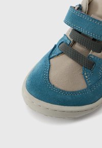 Παιδικό παπούτσι από μπλε σουέτ και μπεζ δέρμα με στρογγυλεμένη μύτη, καουτσούκ σόλα και λουρί με βέλκρο, με διακοσμητικές ραφές και υφασμένα στοιχεία.