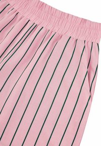 Tissu rose avec des rayures verticales vertes, présentant une taille élastique froncée. Le matériau semble léger avec une texture lisse.