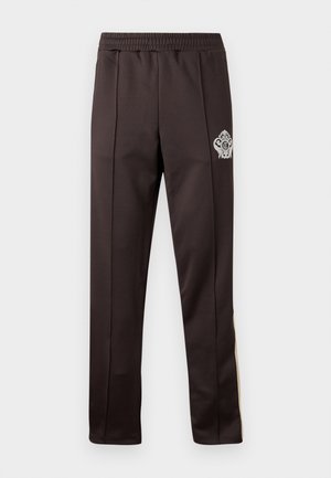 Donkerbruine broek met rechte pijpen, elastische tailleband en een klein wit sierlijk embleem op de bovenste linker dij.