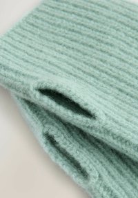Zachte, lichtgroene gebreide sjaal met geribbelde textuur en open uiteinden. Gemaakt van wol, met een gezellige en dikke uitstraling voor warmte.
