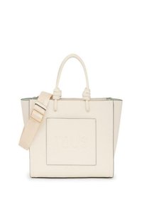Torebka tote w kolorze kremowym, wykonana ze skóry, z podwójnymi uchwytami u góry, odczepianym paskiem, wytłoczonym logo oraz kontrastowym przeszyciem na brzegach.