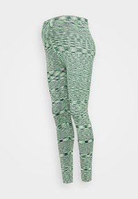 Leggings verdes estampados feitos de tecido elástico, apresentando um design em grade com diferentes tons de verde e preto.