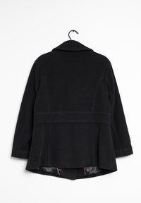 Svart ullkappa med bred krage, sömdetaljer och midjeresår. Fodrad insida med kontrasterande röda detaljer vid fållen.