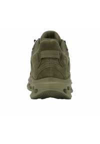 Zapatilla deportiva de color verde oliva vista desde atrás, con parte superior de ante y malla, suela texturizada, tirador en el talón y logo de la marca en el lateral.