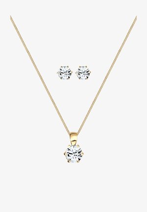 Guldtonet smykker sæt bestående af en krystalvedhæng halskæde med en tynd kæde og matchende runde studs, der alle præsenterer klare krystaller.