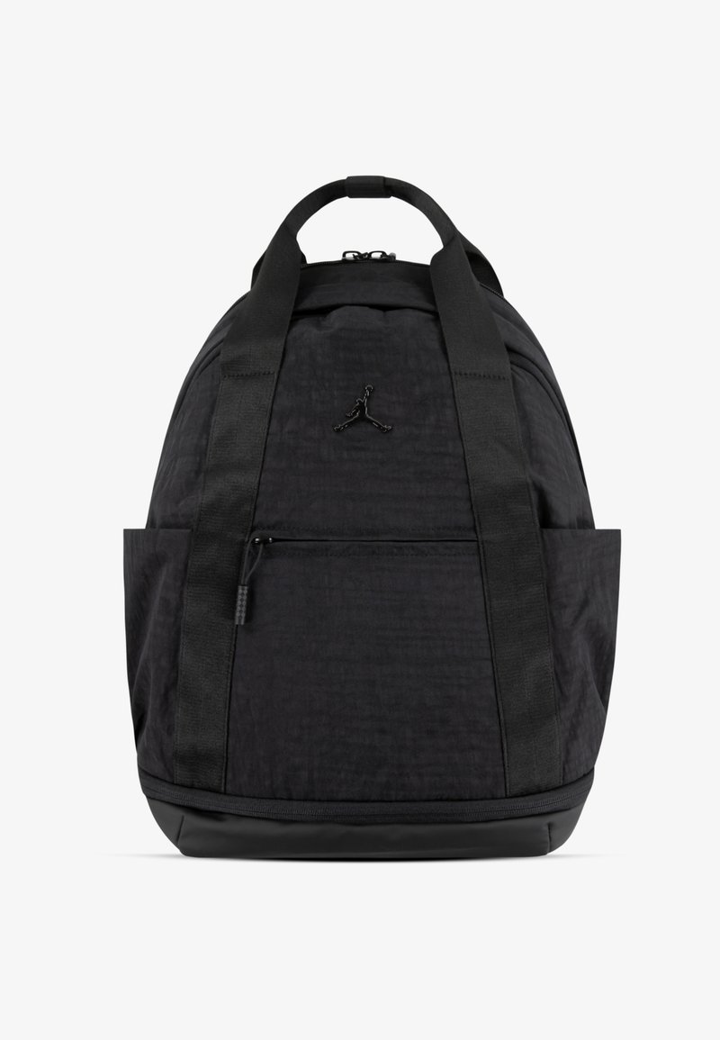 Mochila preta com tecido texturizado, alças planas e bolso frontal com fecho. Apresenta um logo na frente e uma base arredondada para estabilidade.