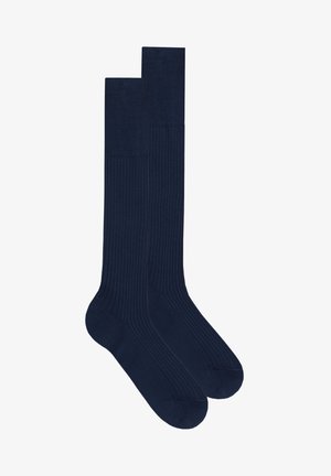 Mörkblå knähöga strumpor tillverkade av ett mjukt, slätt material. Har ribbat mönster på toppen, med förstärkt tå och häl.