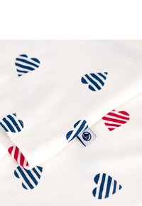 Katoenstof met afwisselend gestreepte harten in donkerblauw en rood, tegen een witte achtergrond. Inclusief een klein merklabel.