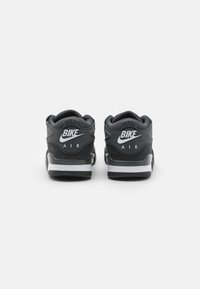 Sorte sneakers med høy ankelsupport, teksturert syntetisk materiale, hvite logoaksenter, polstret krage og kontrasterende såledesign.