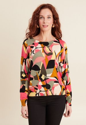 Pull en tricot multicolore avec des motifs abstraits en rose, vert, noir et moutarde. Il possède un col rond et des manches longues.