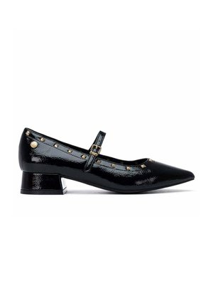 Scarpa in pelle verniciata nera con tacco basso, punta appuntita, cinturino alla caviglia, borchie dorate lungo il bordo e piccolo emblema rotondo dorato vicino al tallone.