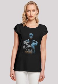 Svart bomull T-skjorte med grafisk trykk av Batman, med blå aksenter og muskuløs design, korte ermer og en avslappet passform.