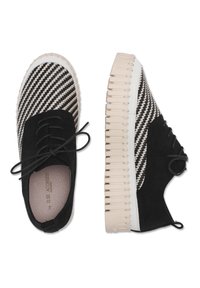 Zapatos de tela de patrón en blanco y negro con parte superior de ante, punta redonda y suela de goma gruesa y estriada. Diseño de cordones detallado.