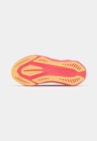 Sohle eines Sneakers mit einem leuchtend pinken Design und gelben Akzenten, texturiert für Traktion und mit einem Muster für Grip.