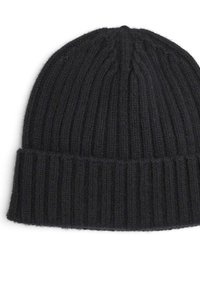 Zwarte gebreide beanie met ribbeltextuur en omgeslagen ontwerp. Materiaal lijkt zacht en dik, geschikt voor koud weer.