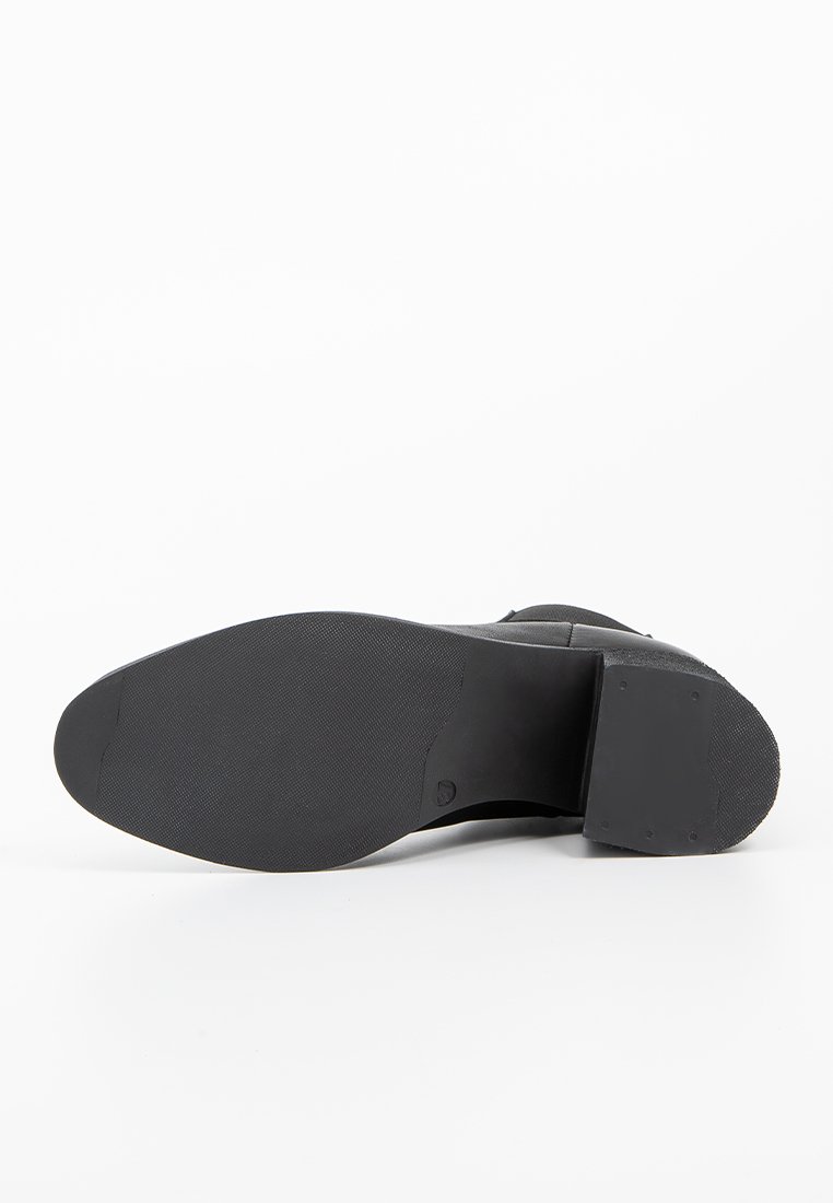 Suola di scarpa eleganti nera con tacco basso quadrato e superficie inferiore testurizzata per una migliore aderenza, mostrata su uno sfondo bianco.