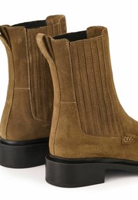 Brązowe zamszowe botki za kostkę z prążkowanymi bokami, uchwytami do zakupu i czarnymi gumowymi podeszwami. Wzmocnione szwy zapewniają trwałość.