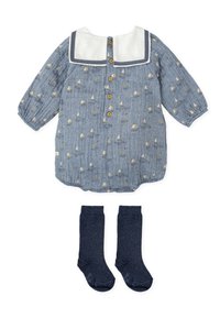 Vestido de chambray azul con estampado de veleros, cuello blanco y botones de madera; combinado con calcetas de algodón azul oscuro hasta la rodilla.