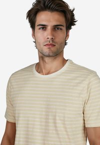 Gestreiftes T-Shirt mit kurzen Ärmeln in Hellgelb und Weiß, mit einem Rundhalsausschnitt und weichem, strukturiertem Stoff.