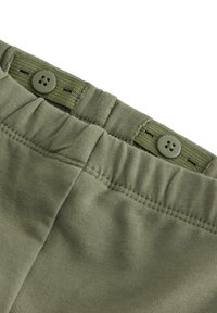 Olivenfarvede bomuldsshorts med en tekstureret talje, der har knaplukninger og elastik for justerbar pasform.