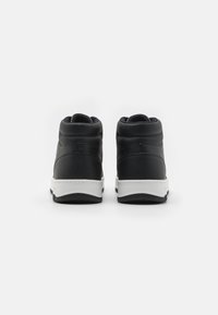 Sneakers alte nere con finitura in pelle texturizzata, suola bianca, supporto per la caviglia imbottito e dettagli di cucitura a contrasto.