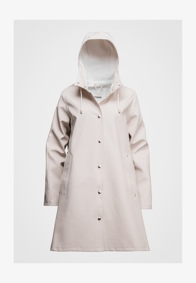 Beige regenjas gemaakt van glad, waterdicht materiaal. Voorzien van een capuchon, drukknoopsluiting en twee zijzakken. Eenvoudig ontwerp met logo nabij de zoom.