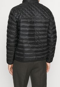 Sort quilted pufferjakke med stående krave, der har vandrette og diamantmønstre på et blankt stof, samt en let tætsiddende pasform.