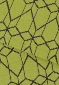 Tissu vert présentant un motif géométrique de losanges interconnectés soulignés en noir. La texture semble douce et tissée.