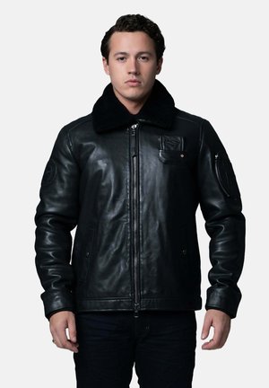 Veste en cuir noir avec un col en fourrure noire douce, fermeture éclair à l'avant et poches latérales. Comprend une épaule brodée et des coutures détaillées.