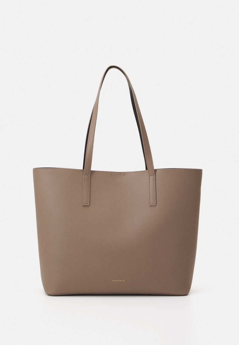 Bolsa tote marrón hecha de material sintético texturizado, con dos asas resistentes y un diseño minimalista. Presenta un pequeño logo dorado en la parte inferior.