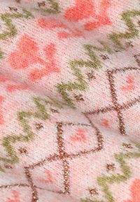 Tissu tricoté avec une base rose ornée de motifs floraux en corail et vert, rehaussé de fils métalliques subtils en formes géométriques.