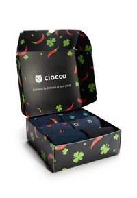 Die Verpackungsbox hat einen schwarzen Hintergrund mit roten Chili- und grünen Kleeblattmustern. Sie enthält drei Paar Socken in dunklen Farben mit verschiedenen Designs.