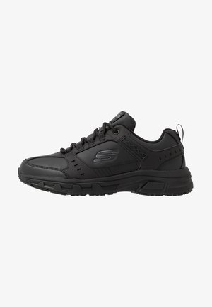 Sapatos atléticos pretos com parte superior sintética, fecho com atacadores, colarinho acolchoado, detalhes texturizados e sola de borracha para tração.