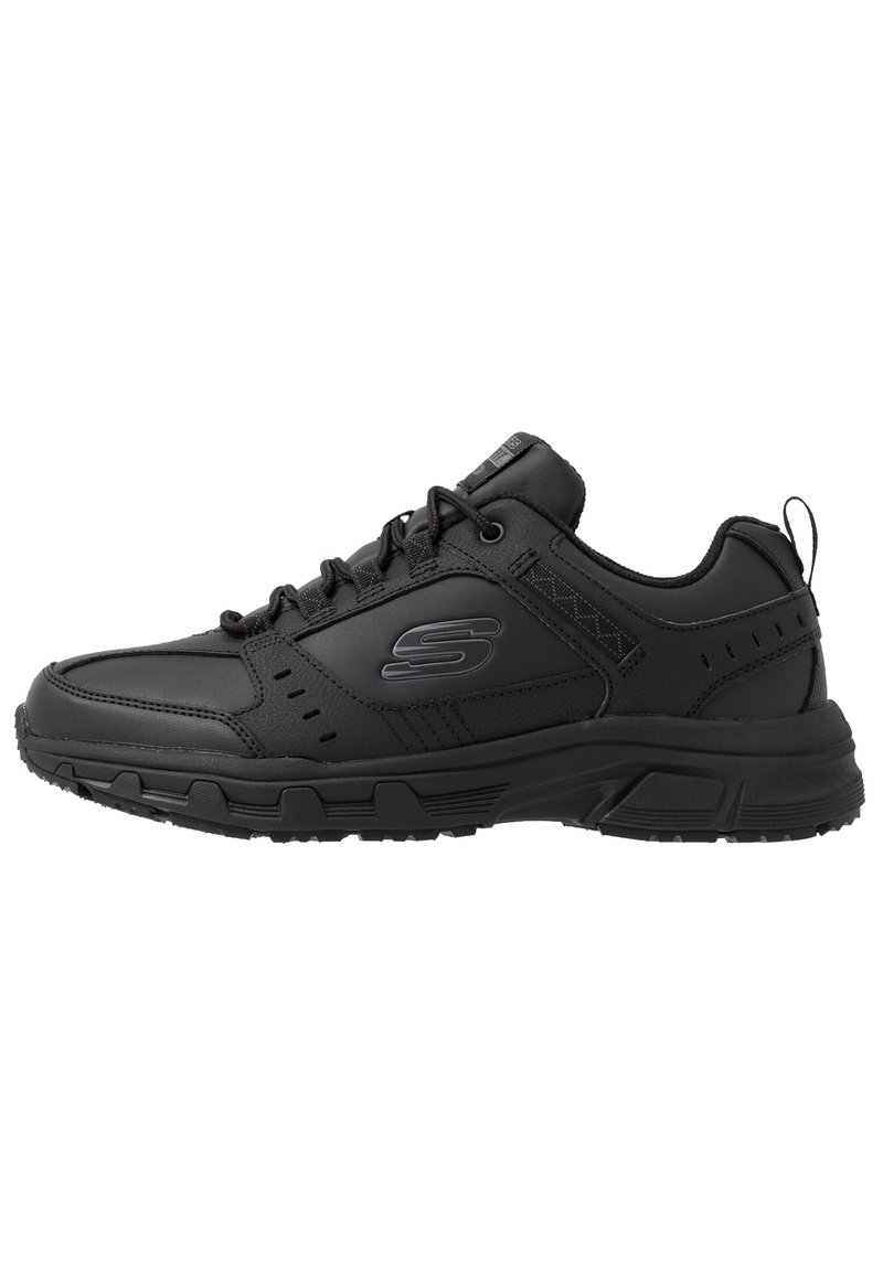 Black athletic shoes with a synthetic upper, lace closure, padded collar, textured detailing, and a rubber outsole for traction.