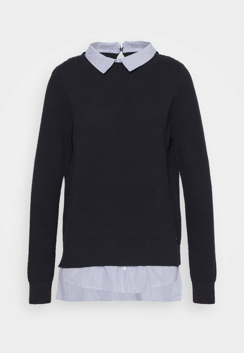 Czarny sweter o teksturowanej powierzchni z jasnoniebieską, pasiastą koszulą pod spodem, z zapięciem na zamek z tyłu oraz ściągaczami na mankietach i u dołu.