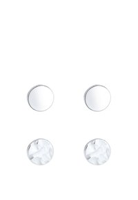 Set de patru cercei: două stud-uri circulare netede din argint și două stud-uri rotunde transparente cu un model geometric texturat.