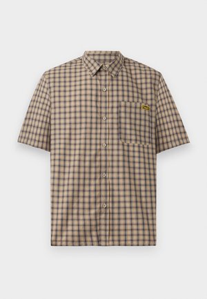 Camisa de cuadros de manga corta en beige con cuadros en azul marino y marrón, con un bolsillo en el pecho y un logo amarillo en el bolsillo.