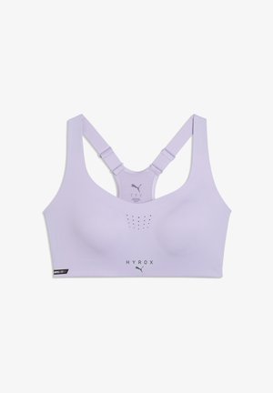 Sujetador deportivo color lila claro con tirantes ajustables de estilo racerback, pequeños agujeros de ventilación en la parte frontal y logotipos de "HYROX" y Puma en la parte inferior.