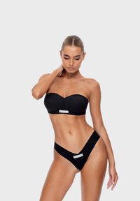 Černý bikini set se stahovacím topem a V-špičatým spodním dílem. Obsahuje značkové detaily a hladkou, matnou texturu. Jednoduchý, elegantní design.