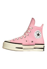 Baskets montantes en toile rose avec lacets blancs, embout en caoutchouc, accents noirs et un patch circulaire du logo sur la cheville extérieure.