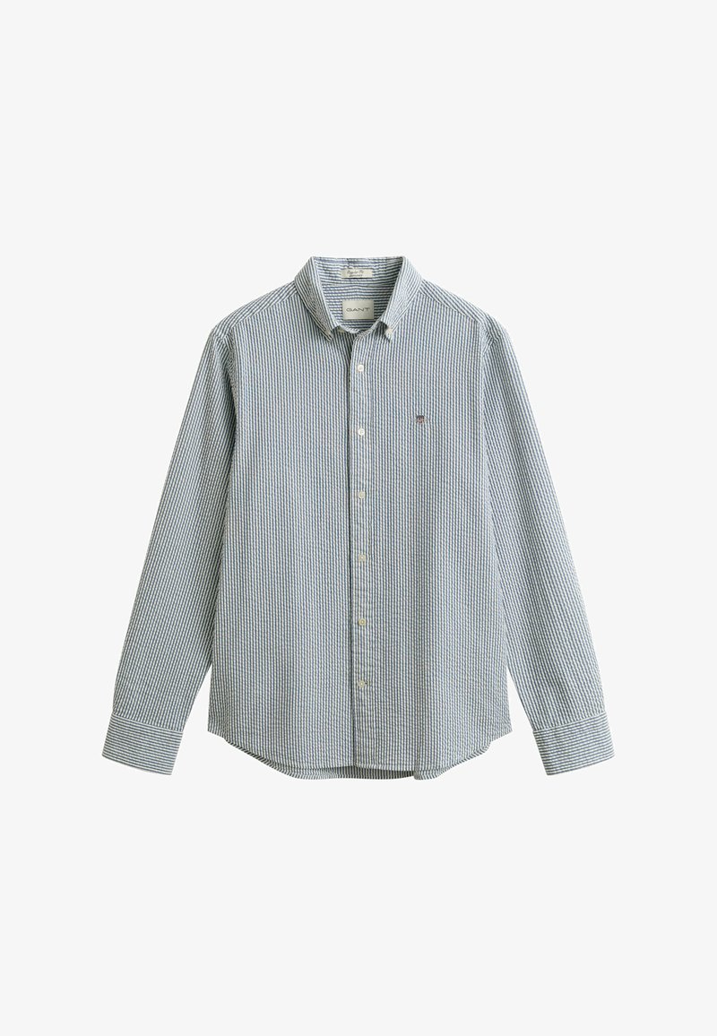 Camisa de manga larga con botones, de rayas verticales azules y blancas, con un pequeño logo bordado en el pecho izquierdo.