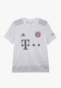 Camiseta de fútbol blanca con acentos grises, que presenta la mitad inferior texturizada, logotipo "T." en el frente, logotipo de Adidas y emblema del Bayern de Múnich.