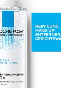 Clear cleansing fluid in a transparent bottle with a blue label. Features a minimalist design with blue accents and text.