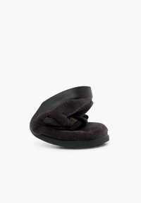 Suola in gomma nera con una parte superiore in morbido velluto viola scuro, caratterizzata da un design a strappo ad anello e un sottopiede imbottito per il comfort.