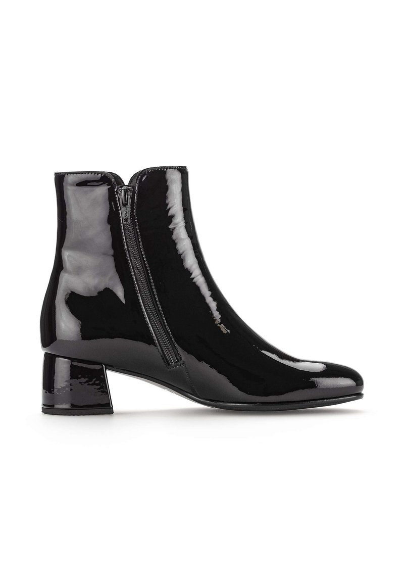 Botines de charol negro con punta afilada, cremallera lateral y tacón cuadrado. Textura suave con un acabado de alto brillo.