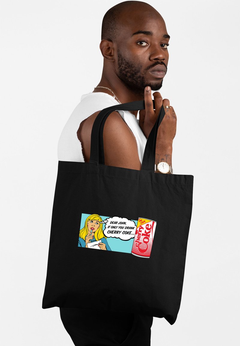 Czarna torba na ramię wykonana z tkaniny, z nadrukiem komiksowym przedstawiającym blond postać oraz logo Cherry Coke w jaskrawych kolorach.
